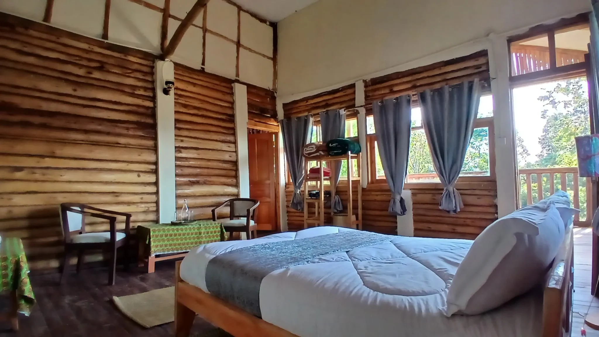 Parents' bedroom at Orugano Bwindi Lodge featuring scenic exterior forest views and a private interconnecting door to the second room